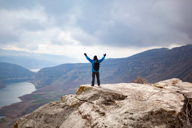 istock A man with his arms raised on a mountain. 1303389277