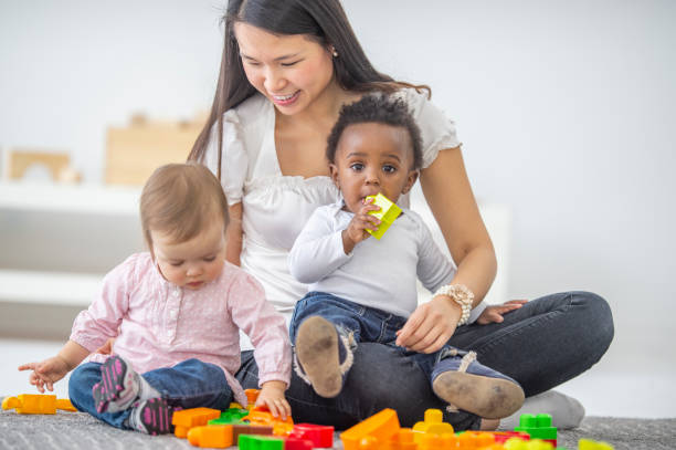 istock Asian female preschool teacher playing with her students 1303392717