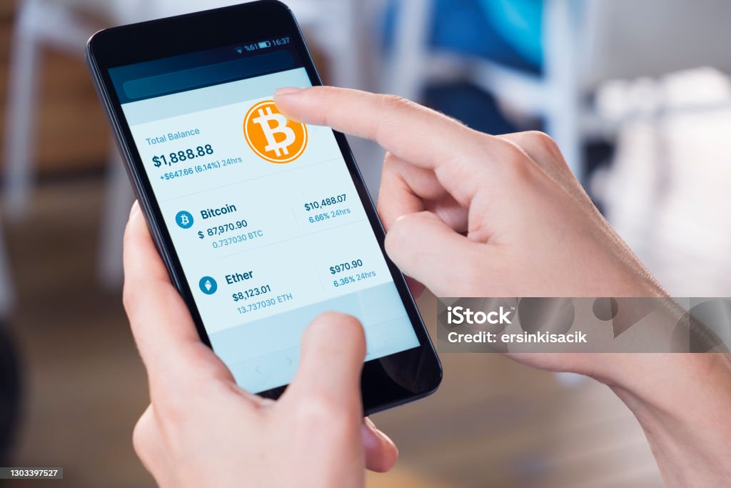 Bitcoin - Crypto Currency Wallet On A mobile Phone Woman using a smart phone displaying a bitcoin wallet screen. Cryptocurrency Stock Photo