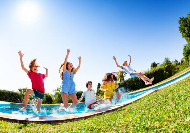 istock Many nice kids fall and splash into the pool water 1303401902