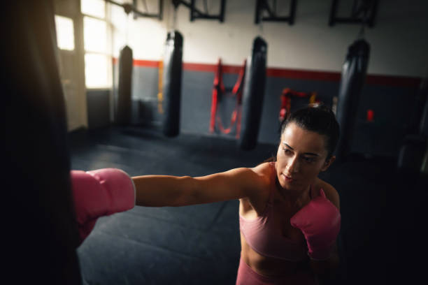 istock Young fit woman direct punch a heavy bag 1303402074