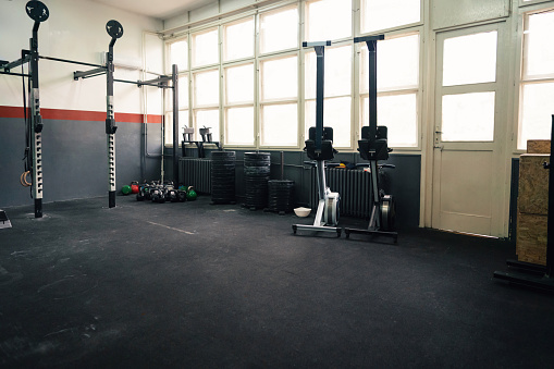 Large group with exercise machines and equipment in a gym.