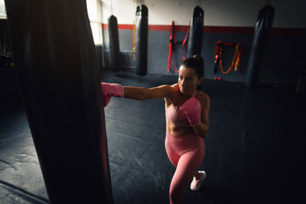 istock Young fit woman direct punch a heavy bag 1303402125