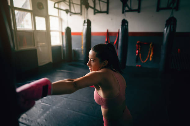 istock Young fit woman direct punch a heavy bag 1303402128