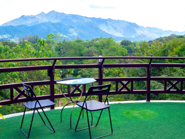 istock Green forest and mountain view background with empty table set on the terrace. 1303408131