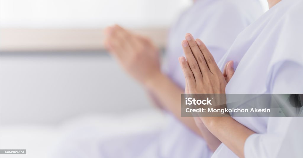 hands of religious Asian buddhist people in white cloth praying and chanting Buddha Stock Photo