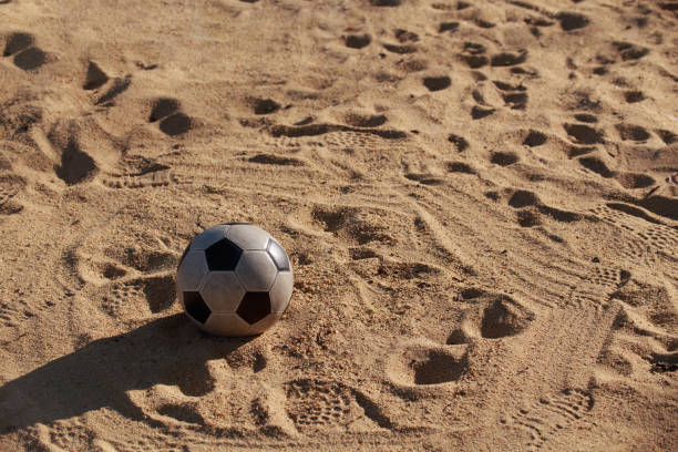 The image shows a local amateur rugby team training on the beach. The activity is reflected as teamwork required