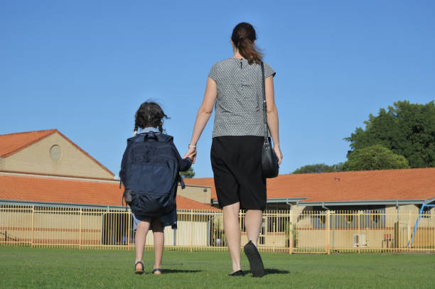 istock Mother walking daughter to school 1303411055