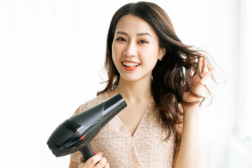 Woman sitting drying hair with a happy expression