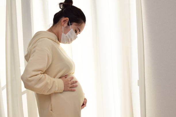 istock pregnant woman wears a mask 1303420272