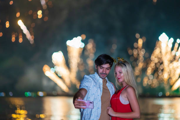 Young couple enjoy firework during celebration festival on the beach.