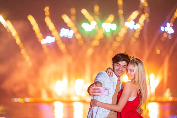 istock Young couple enjoy firework during celebration festival on the beach. 1303423206