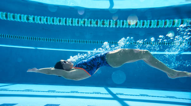istock One woman with disabilities doing backstroke underwater. 1303424397