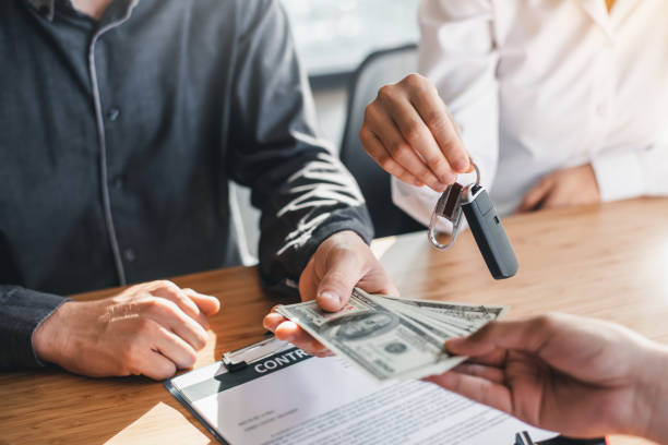 negocio firmando una compra de contrato - vender coche. joven pareja está firmando contrato de compra o venta de coches y obtiene la llave para el nuevo coche. - car insurance sales occupation buying fotografías e imágenes de stock