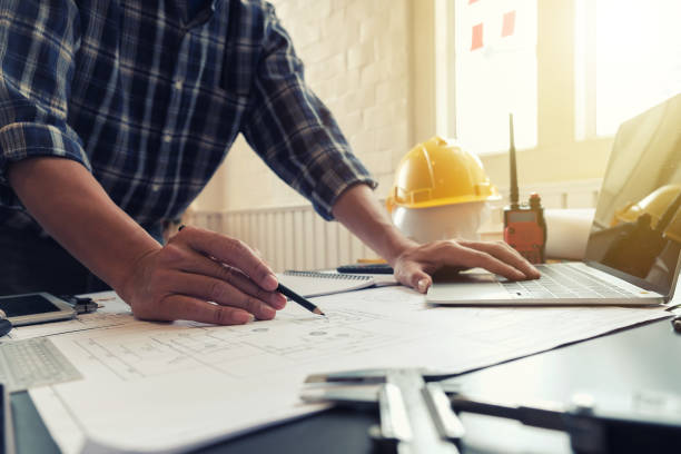 istock Young man engineer working on blueprint Planning and drawing of construction project. 1303428151