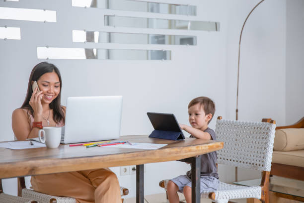 istock Indonesian Mother Working From Home with Her Son Beside Her 1303428236