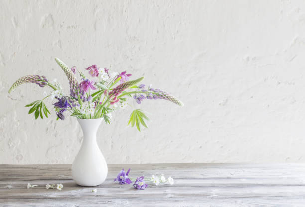 istock summer flowers in vase on background white wall 1303431395