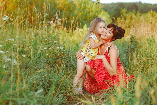 istock mother sitting on the grass with children 1303432995