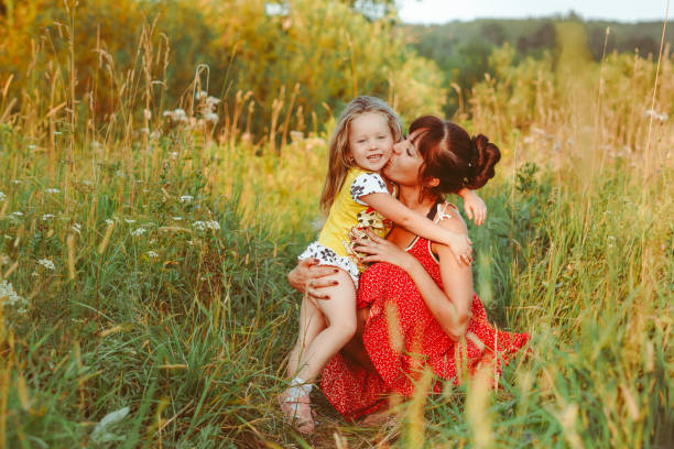 istock mother sitting on the grass with children 1303433065