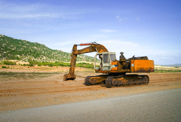 istock Excavator on a construction site, next to a hill, in earthmoving construction project or road works. 1303433800