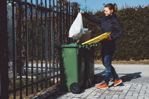 istock Woman dropping a garbage bag in the trash can 1303442098