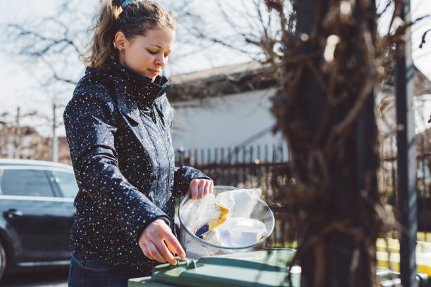 giovane donna caucasica che ricicla rifiuti di plastica all'esterno - looking at camera full length outdoors image technique foto e immagini stock