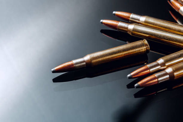 istock Rifle bullets or cartridges on black shiny background 1303442492