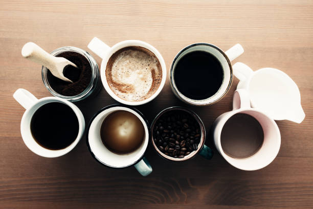 istock Multiple coffee cups, milk, beans and ground coffee in jar on wooden background 1303443580