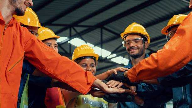 Skillful worker stand together showing teamwork in the factory . stock photo
