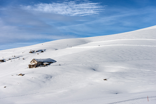 Altopiano della Lessinia (Lessinia Plateau), near Malga San Giorgio, ski resort in Verona province, Veneto, Italy, Europe. Old stone Farmhouse and cross-country ski tracks in winter with snow.
