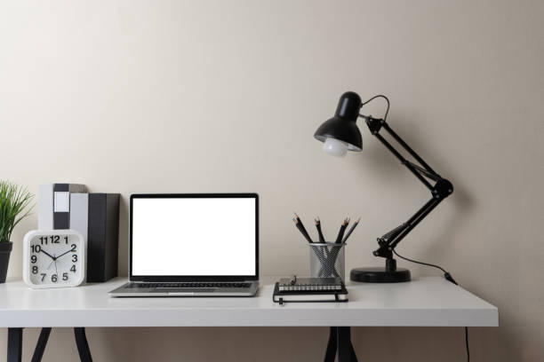 istock Modern contemporary workspace with blank screen laptop computer with office supplies and stationery on office desk on white background for copy space. Home office workplace concept. 1303446459