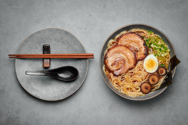 コンクリートテーブルトップの上にグレーボウルの醤油ラーメン。茶州ポークと和食肉麺スープ。アジア料理。トップビュー - edible mushroom shiitake mushroom fungus chinese cuisine ストックフォトと画像