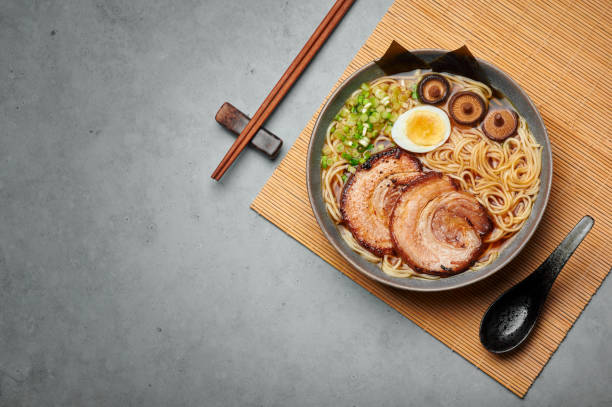 コンクリートテーブルトップの上にグレーボウルの醤油ラーメン。茶州ポークと和食肉麺スープ。アジア料理。トップ ビュー。スペースをコピーする - edible mushroom shiitake mushroom fungus chinese cuisine ストックフォトと画像