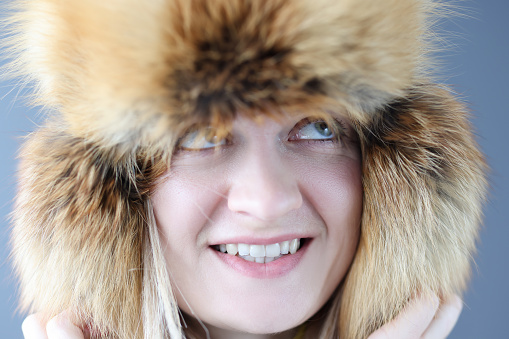 Portrait of young woman in warm hat. Sale of fur products concept