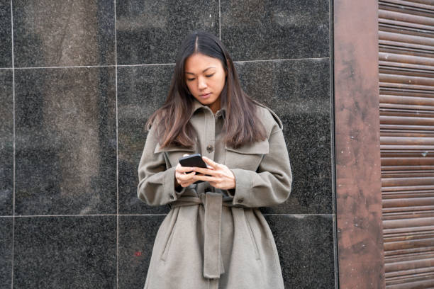 istock Woman using cellphone on the street 1303448863