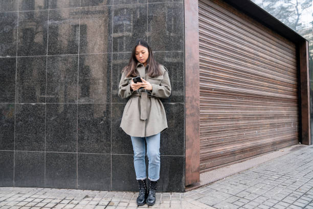 istock Woman using cellphone on the street 1303448868