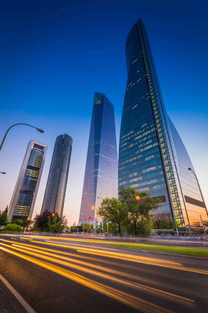 ruch autostradowy powiększający się obok futurystycznych wieżowców cuatro torres madryt hiszpania - paseo de la castellana zdjęcia i obrazy z banku zdjęć