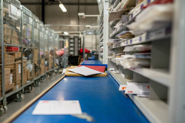 Letters on a table in a mail centre sorting office Letters on a sorting frame, table and shelves in a mail delivery sorting centre. Postal service, post office inside mail stock pictures, royalty-free photos & images