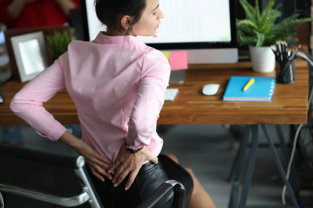 mujer siente dolor de espalda doloroso sentado lugar de trabajo - posture office isolated physical injury fotografías e imágenes de stock