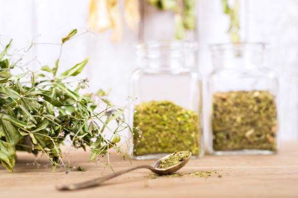 istock Herbal tea and dried herbs or medicine in jars with spoon 1303455657