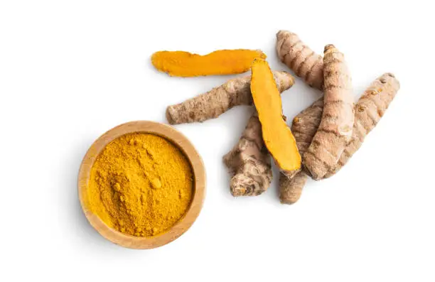 Indian turmeric powder and root. Turmeric spice. Ground turmeric isolated on white background.