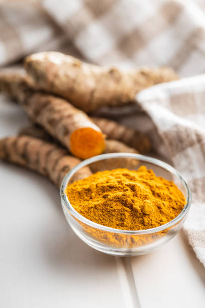 istock Indian turmeric powder and root. Turmeric spice. Ground turmeric 1303456206