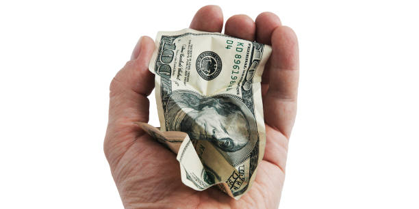 istock A crumpled hundred-dollar cash bill in his hand. 1303457612