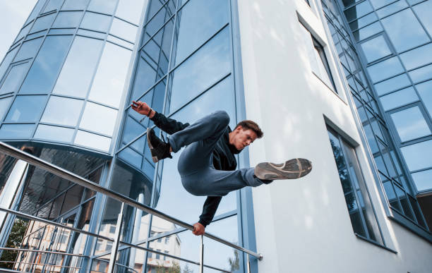 Young man doing parkour in the city at daytime. Conception of extreme sports Young man doing parkour in the city at daytime. Conception of extreme sports. free running stock pictures, royalty-free photos & images