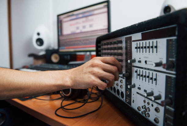 Using the mixer. Sound engineer working indoors in the studio