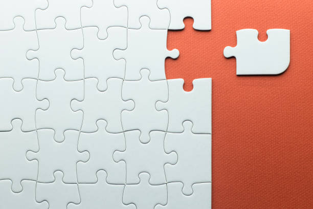 istock puzzle piece that does not fit with the others, white puzzle pieces on a red textured background 1303461870