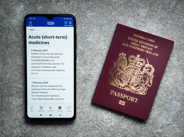 The UK's NHS smartphone app shows evidence of an Oxford AstraZeneca COVID vaccination given given on 2nd February 2021. A UK passport appears on the right. The UK's NHS smartphone app shows evidence of an Oxford AstraZeneca COVID vaccination given given on 2nd February 2021. A UK passport appears on the right. vaccine passport photos stock pictures, royalty-free photos & images