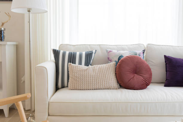 istock Decorative pillows on sofa with floor lamp. 1303462908