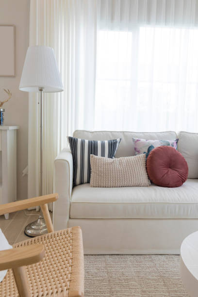 istock Decorative pillows on sofa with floor lamp. 1303462915