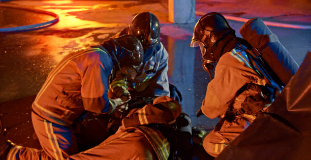 istock Firefighters helping injured man 1303463181